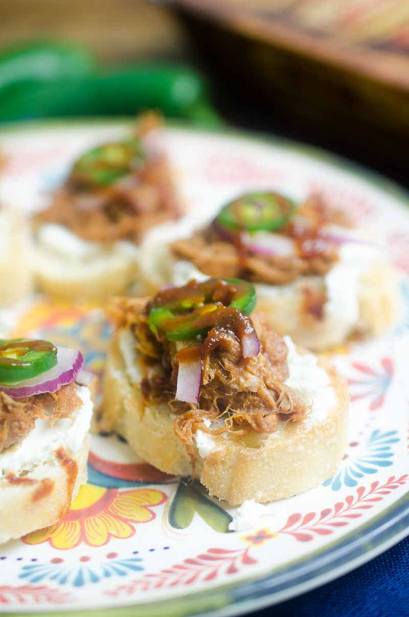 BBQ Pulled Pork Bruschetta is topped with goat cheese, Curly’s RoadTrip Eats West Coast IPA Style Pulled Pork, onions, jalapenos and BBQ sauce. It’s perfect for game day!