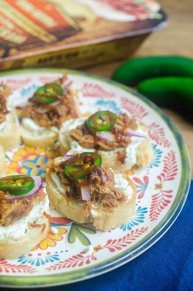  BBQ Pulled Pork Bruschetta is topped with goat cheese, Curly’s RoadTrip Eats West Coast IPA Style Pulled Pork, onions, jalapenos and BBQ sauce. It’s perfect for game day!