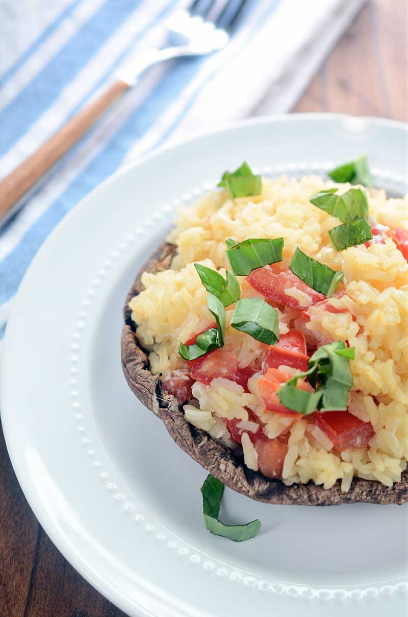 Garlic Rice Stuffed Portobello Mushrooms are stuffed with garlic rice, tomatoes and goat cheese then sprinkled with fresh basil. It is a hearty dish that is great as a side dish or a vegetarian main dish. 