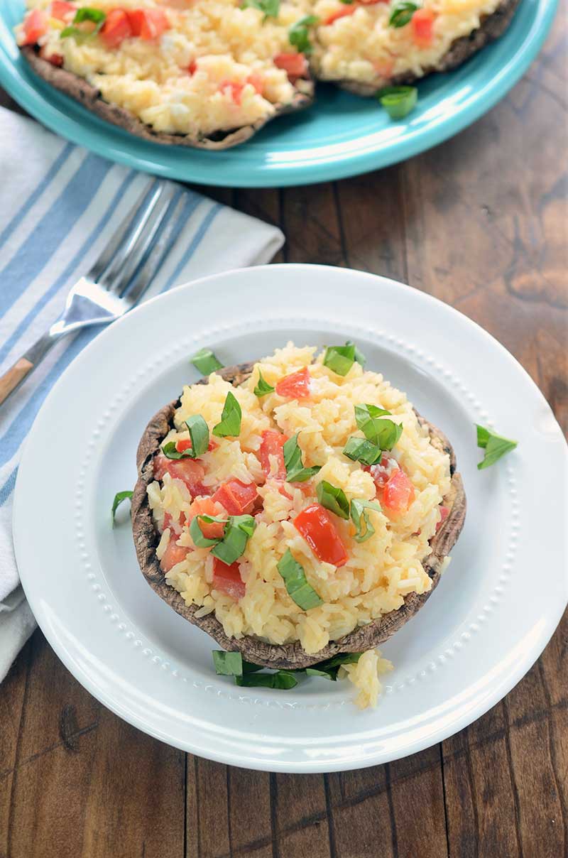 Garlic Rice Stuffed Portobello Mushrooms are stuffed with garlic rice, tomatoes and goat cheese then sprinkled with fresh basil. It is a hearty dish that is great as a side dish or a vegetarian main dish. 