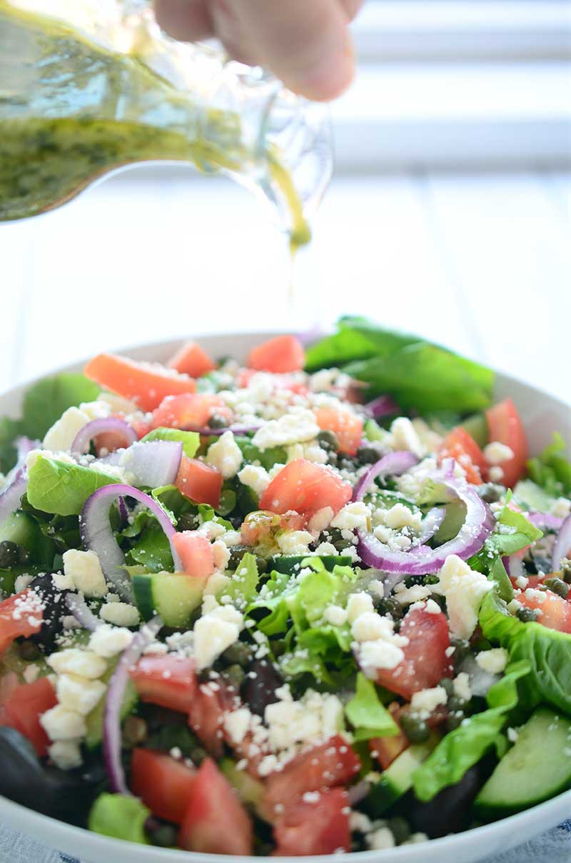 This Loaded Greek Salad has all kinds of goodies: olives, tomatoes, cucumbers, red onion, capers and feta and is tossed in a tangy Oregano vinaigrette.