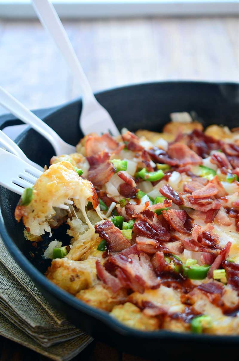 These loaded tailgate tots are perfect for game day! They are loaded with 2 cheeses, onions, jalapeños, bacon and then drizzled with BBQ sauce. 