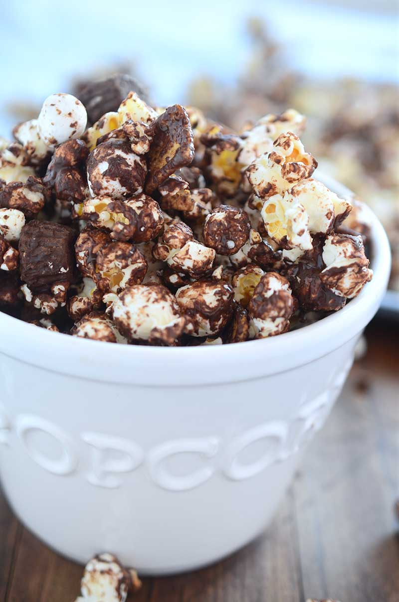 Peanut Butter Cup S'mores Popcorn one heck of a salty/sweet snack. It is loaded with popcorn, peanut butter cups, marshmallows, graham cereal and chocolate.
