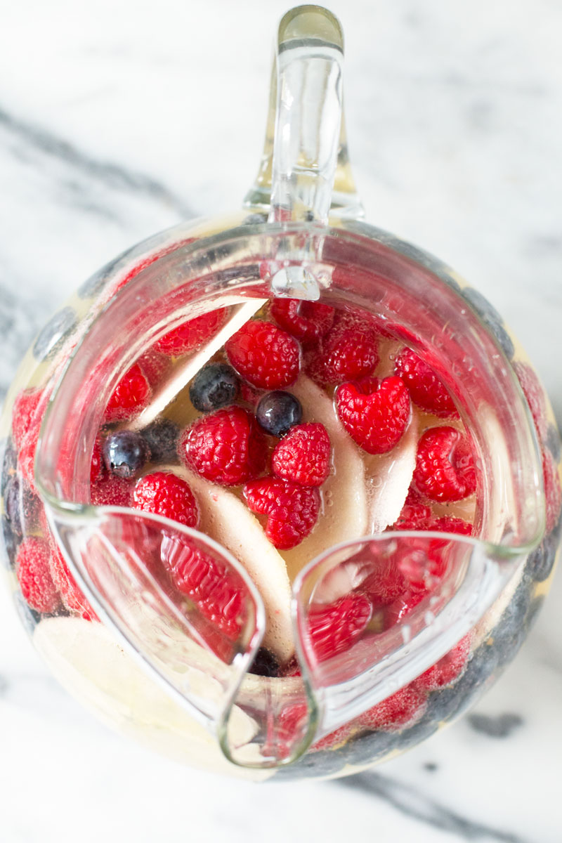 A patriotic twist on Sangria this colorful red, white and blue sangria with raspberries, blueberries and apples is perfect for the 4th of July!