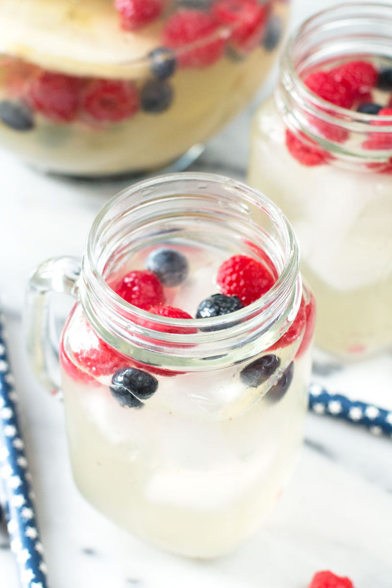 A patriotic twist on Sangria this colorful red, white and blue sangria with raspberries, blueberries and apples is perfect for the 4th of July!