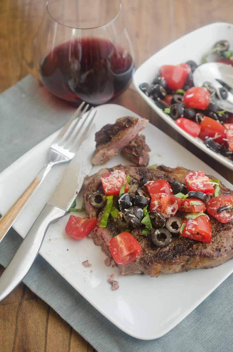 Ribeye steaks with fresh tomato tapenade are is the grilling recipe that you need this summer! Beefy goodness, topped with sweet summer tomatoes, it doesn't get much better. 