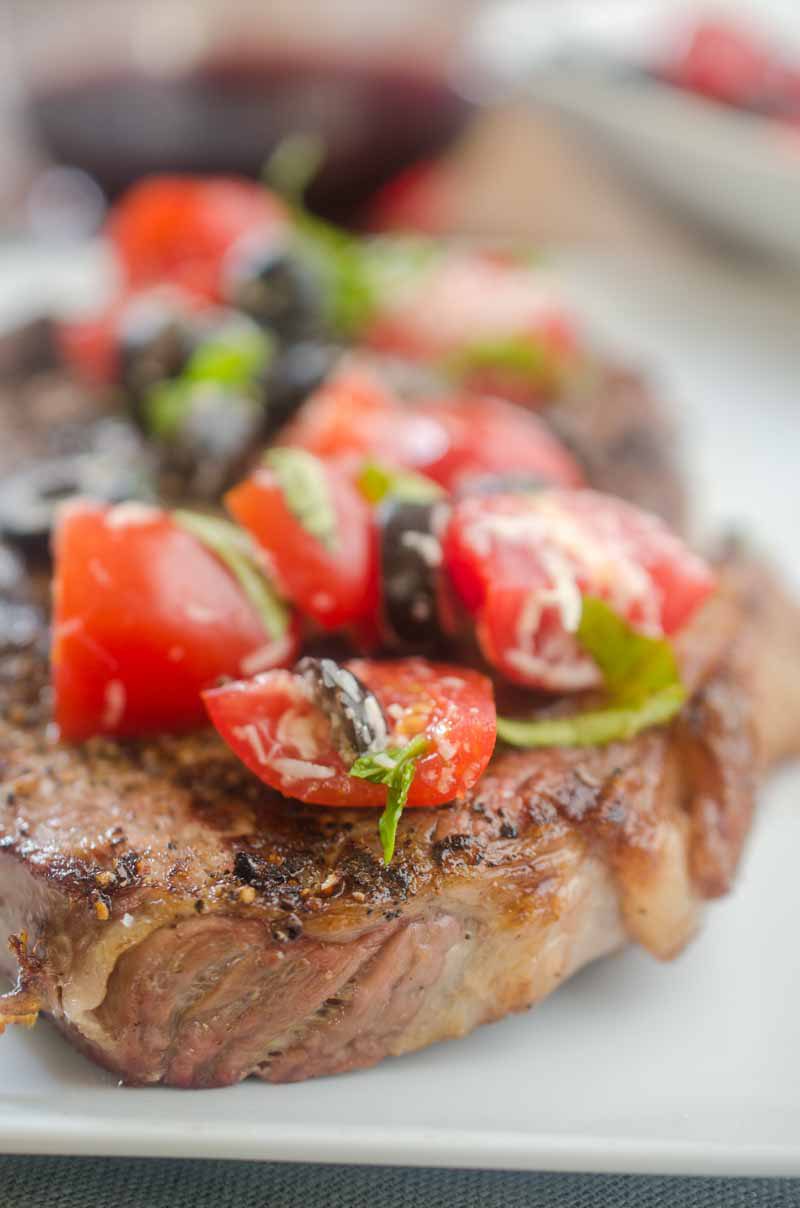 Ribeye steaks with fresh tomato tapenade are is the grilling recipe that you need this summer! Beefy goodness, topped with sweet summer tomatoes, it doesn't get much better. 