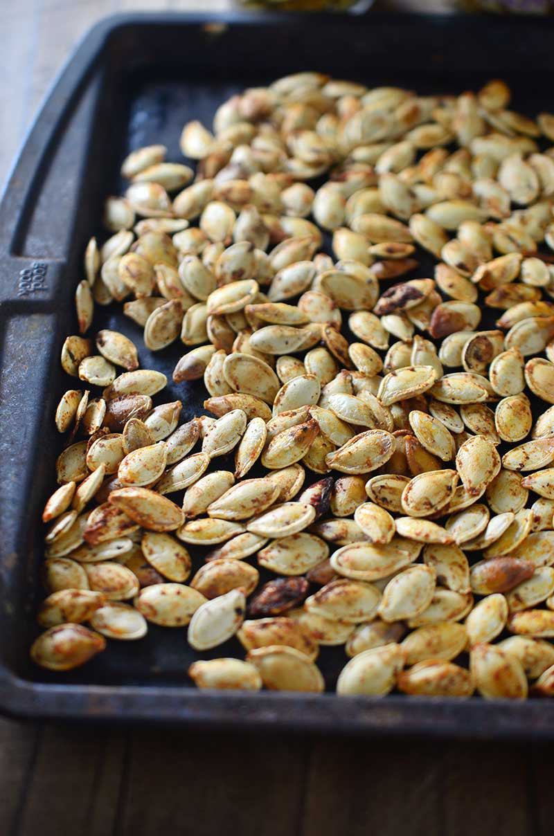 Roasted Pumpkin Seeds are a wonderful fall snack! Here are two different flavors to serve them: tossed in garlicky oil and butter and tossed in a spicy curry powder. 