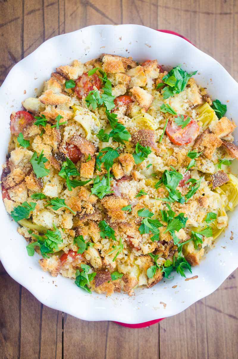 Tomato Artichoke Bake is the perfect side! It's loaded with artichoke hearts, fresh bread crumbs, tomatoes, grated parmesan and then baked until golden.