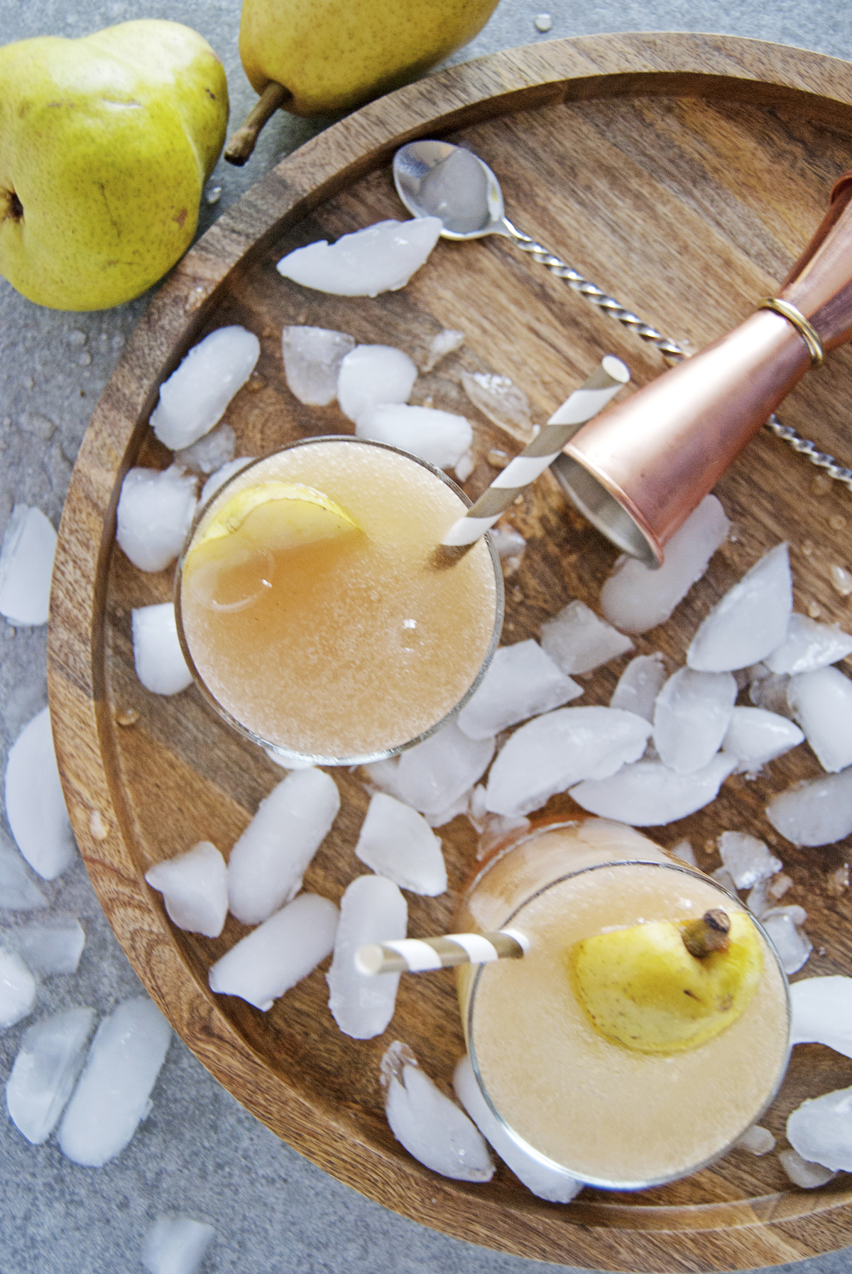 These cardamom pear spritzer cocktails feature delicious fresh pear juice, white rum, and a homemade honey cardamom simple syrup.