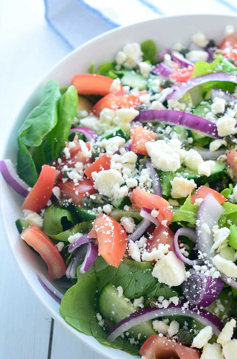 This Loaded Greek Salad has all kinds of goodies: olives, tomatoes, cucumbers, red onion, capers and feta and is tossed in a tangy Oregano vinaigrette.