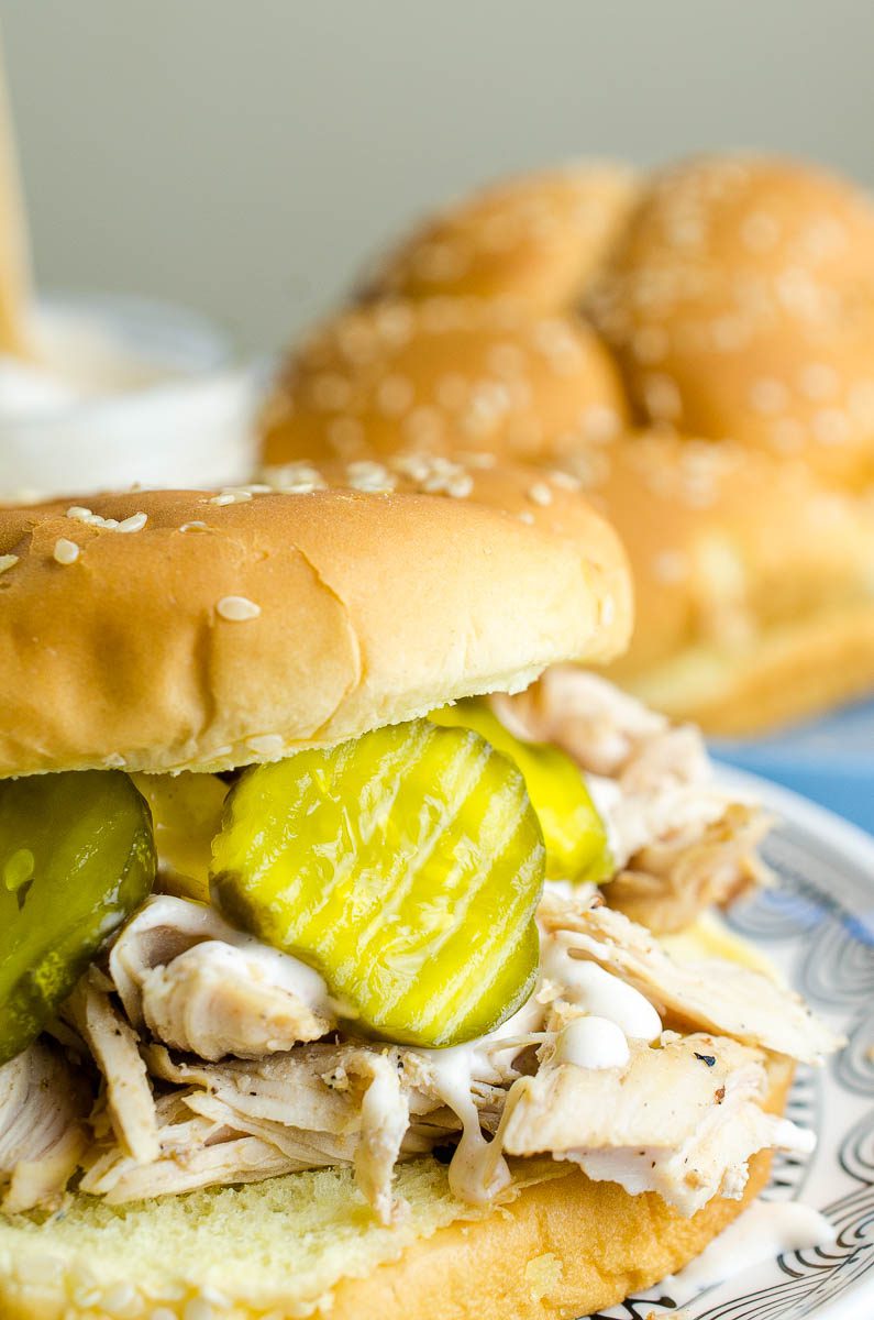 This easy pulled chicken sandwich is made with chicken marinated in Alabama BBQ sauce, grilled, shredded and topped with more Alabama BBQ and bread and butter pickles. The perfect summer sandwich!