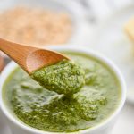 A wooden spoonful of basil pesto.