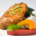 Glazed asian style pork chops on plate with bell peppers.