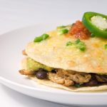 Chicken tortilla stack on white plate.