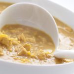 Mulligatawny soup in a white bowl with white ladle