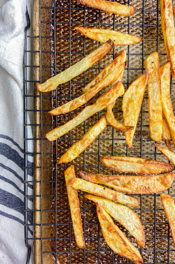 Overhead photo of air fried french fries on a cooling rack on a baking sheet.