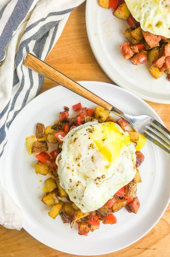 Cajun Breakfast Skillet is loaded with potatoes, andouille sausage, onions, bell peppers and cajun seasoning. Then topped with a perfectly fried egg. It's an easy, hearty way to start your day! 