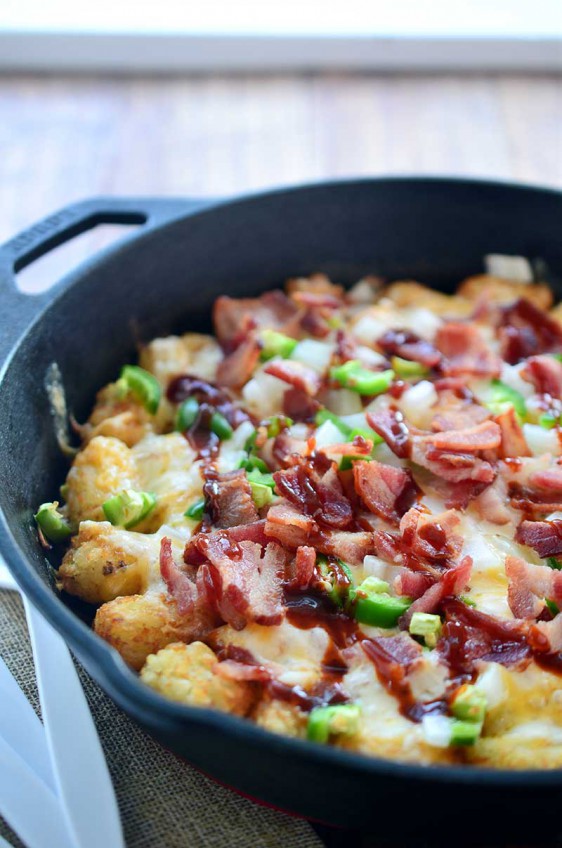 These loaded tailgate tots are perfect for game day! They are loaded with 2 cheeses, onions, jalapeños, bacon and then drizzled with BBQ sauce.
