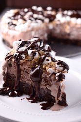 This decadent Oreo Brownie & S'mores Ice Cream Cake has a brownie crust, s'mores ice cream, marshmallows, graham cracker crumbs & chocolate ganache.