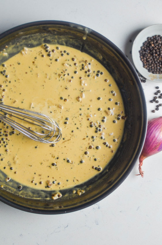 Overhead photo of peppercorn cream sauce in a skillet.