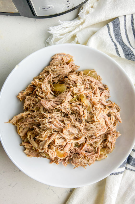 Overhead photo of slow cooker pulled pork in a white bowl.