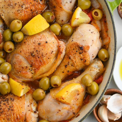 Overhead photo of chicken in pan with olives.