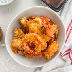 Overhead photo of coconut fried shrimp in white bowl.