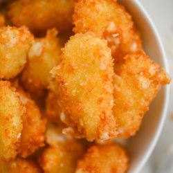 Overhead photo of panko fried cheese curds in a white bowl.
