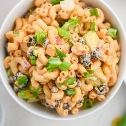 Overhead photo of seven layer dip pasta salad on white background.