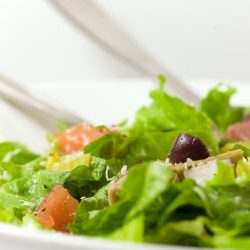 Close up of antipasto salad in white bowl.