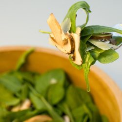 Arugula parmesan mushroom salad on a fork