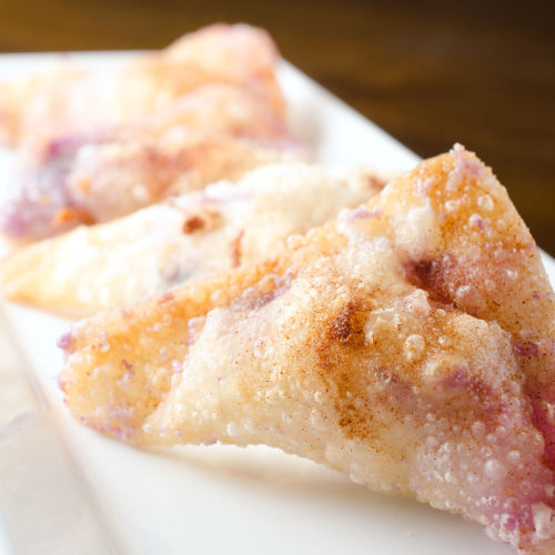 blueberry cream cheese wontons on white plate.