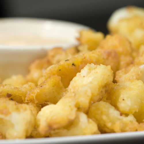 Fried calamari with lemon basil sauce on white plate.