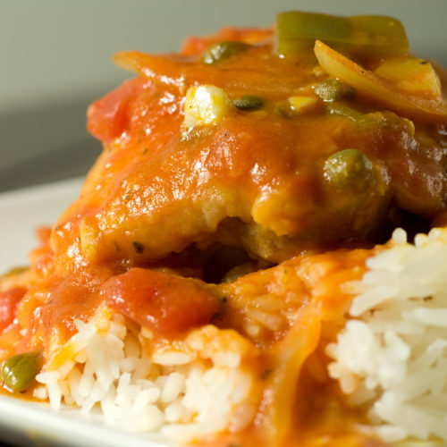 Chicken cacciatore on plate of rice.