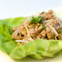 chicken lettuce wrap on white plate.