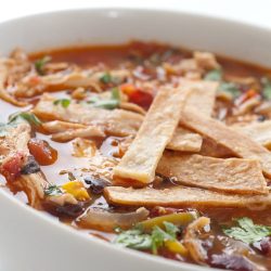 Chicken tortilla soup in white bowl.