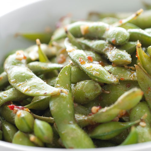 chili garlic edamame in white bowl.