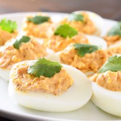 chili deviled eggs on white plate.