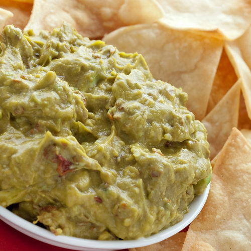 chipotle guacamole in bowl with tortilla chips.