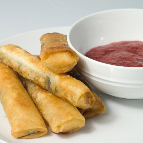 4 chocolate banana lumpia on white plate.