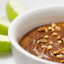 close up of chocolate caramel dip in white bowl.