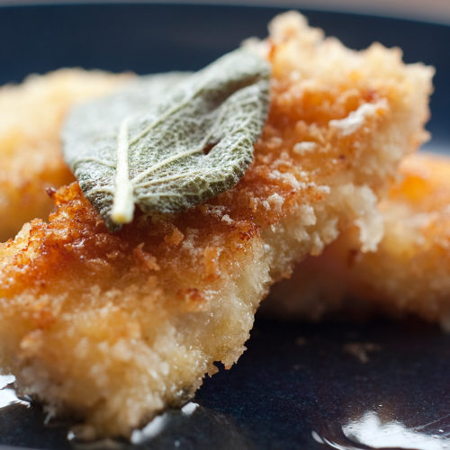 close up of fried cod with sage leaf.