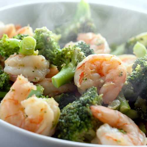 Ginger shrimp and broccoli stir fry in white bowl.