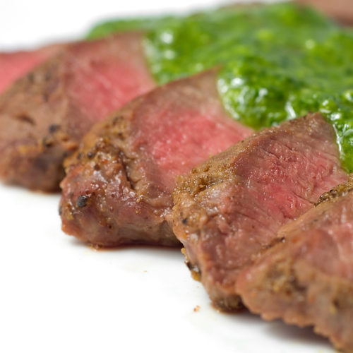 slices of flat iron steak topped with chimichurri