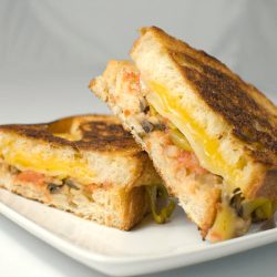 Three cheese grilled cheese sandwich on white plate.
