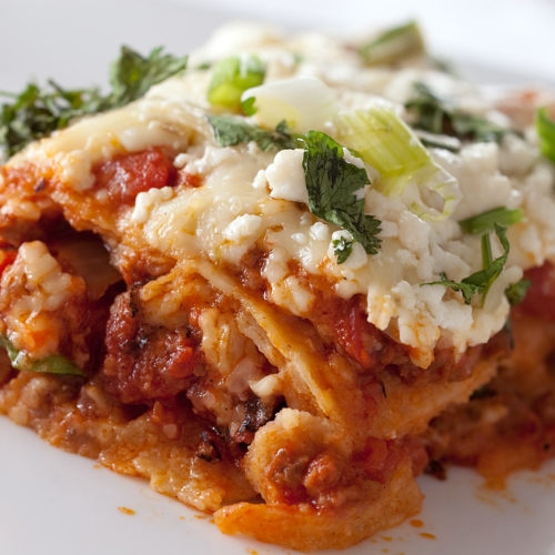 Slice of mexican lasagna on white plate.