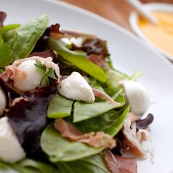 Mozzarella and Prosciutto Salad on a white plate.