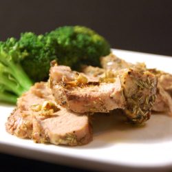 Roasted pork tenderloin on white plate with broccoli