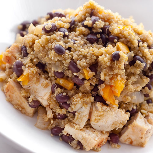Quinoa with chicken and black beans in a white bowl.